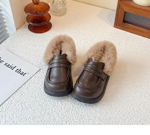 Close-up of children's brown leather loafers with plush faux fur trim for winter