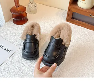 Detail view of children's warm fur-lined black leather loafers for winter