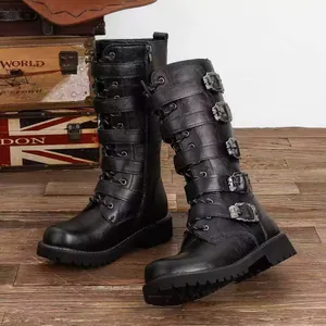 Detailed side view of black gothic tall boots with silver buckles on wood background