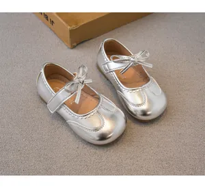 Détail de chaussures Mary Jane argentées pour filles avec un nœud élégant et fini métallisé