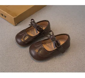 Chaussures babies classiques marron foncé pour fille avec nœud et semelle souple.