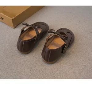 Vue arrière de chaussures de princesse marron pour filles avec nœud papillon