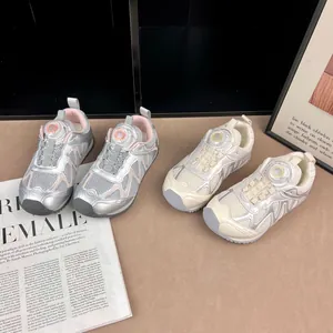 Détails de baskets respirantes pour enfants à boucle rotative en argent et crème.
