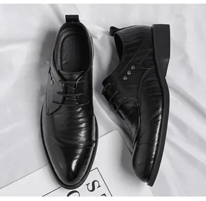 Top view of stylish men's black business dress shoes with hand-grabbed leather texture