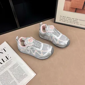 Gros plan détaillé des baskets en maille argentée pour enfants à bouton rose