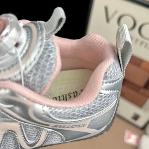 Détail de baskets argentées en maille respirante pour enfants avec bouton rotatif