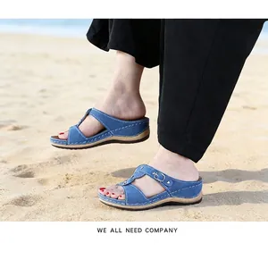 Blue wedge platform sandals with metal buckle shown in a lifestyle beach setting