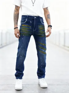 Detail showing men's straight-leg blue jeans featuring unique yellow spray and paint splatters