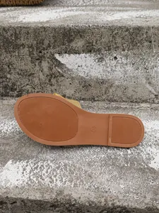 Primer plano de la suela antideslizante texturizada y marca de talla en sandalias planas