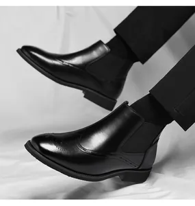 Primo piano di stivali Chelsea in pelle nera con dettagli brogue e inserti elastici laterali