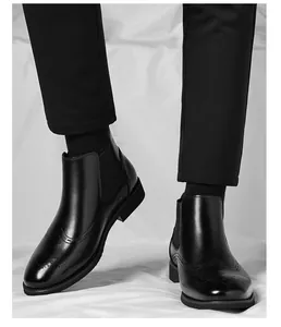 Primo piano di stivaletti Chelsea da uomo in pelle nera con dettagli brogue.