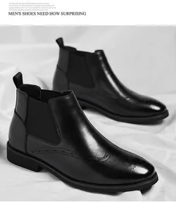 Dettaglio di stivali Chelsea in pelle nera con decorazioni brogue su sfondo bianco.