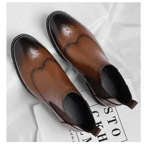 Vista dettagliata di stivali Chelsea marroni con dettagli brogue e inserti elastici laterali.