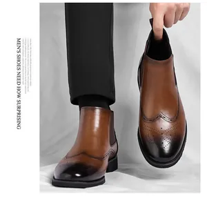 Dettaglio di stivaletti Chelsea in pelle marrone con motivo brogue e punta sfumata