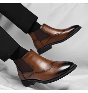 Dettaglio di stivali Chelsea da uomo marroni con decorazioni brogue e finitura pelle