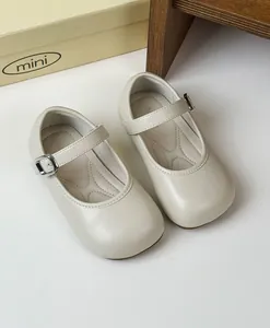 Detail of vintage cream Mary Jane shoes for girls, featuring adjustable buckle straps.