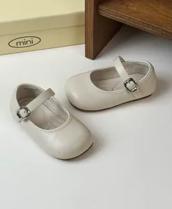 Detail of retro beige girl's Mary Jane princess shoes with metal buckle strap.