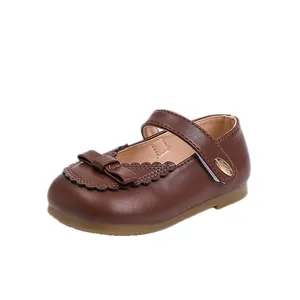 Classic brown faux leather Mary Jane shoes for girls featuring a cute bow and scalloped trim