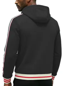 Detail view of black men's hoodie with red and white side stripes and ribbed hem.