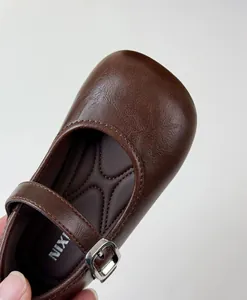Close-up detail of brown vintage French style leather Mary Jane shoes for little girls
