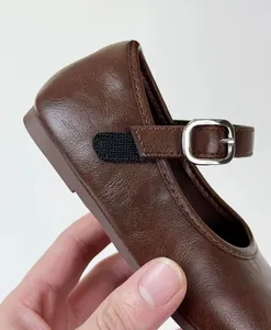 Detailed macro view of vintage brown leather Mary Jane shoe for girls with buckle strap