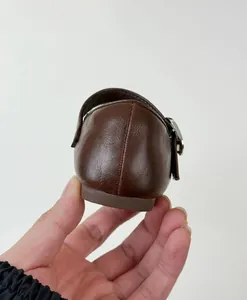 Detailed rear view showing the heel and side buckle of vintage brown girls leather flats