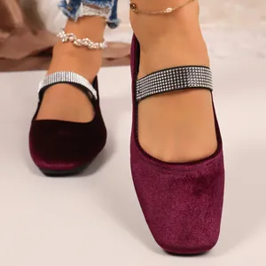 Close-up van elegante paarse fluwelen ballerina's met fonkelende strasbandjes voor dames.