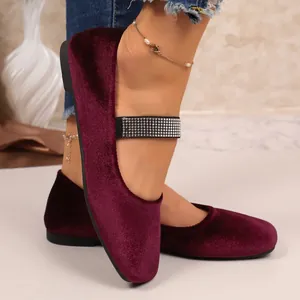 Detailopname van elegante bordeauxrode fluwelen platte schoenen met sprankelende strasband