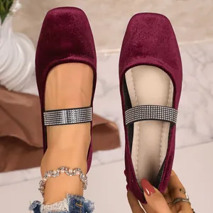 Gedetailleerde weergave van bordeauxrode fluwelen ballerina's met luxe strasbandjes