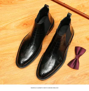 Close-up detail of black leather Chelsea boots featuring vintage engraved patterns on high-quality leather