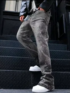Detail of distressed grey paint splatter jeans with a vintage wash and wide-leg fit