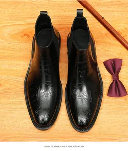 Top view of black leather Chelsea boots with elegant script laser etching details.