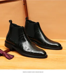 Detail view of black leather Chelsea boots featuring elegant laser-etched patterns