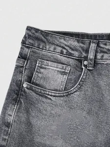 Close-up view of vintage washed grey denim jeans pocket with subtle splash ink detail