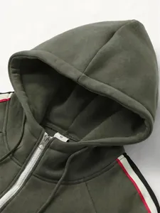Close-up of green zip-up hoodie featuring contrast stripes and hood detail.