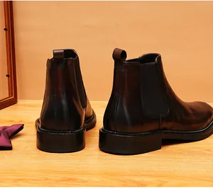 Detailed view of men's leather Chelsea boots with elegant engraving and gradient finish.