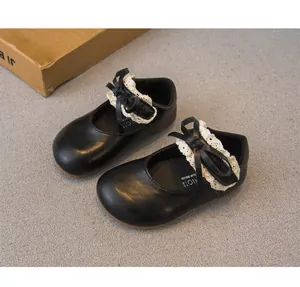 Detailaufnahme von eleganten schwarzen Mädchen-Lederschuhen mit schicker Spitze und Schleife