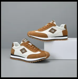 Stijlvolle bruin-witte leren vrijetijdssneakers voor heren op grijze achtergrond