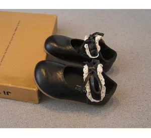 Detailansicht der schwarzen Babymädchen-Prinzessin-Schuhe mit Spitzen-Schleifendekor