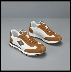 Perspectivisch beeld van bruin-witte leren heren sneakers met specifieke TVWK-logo details