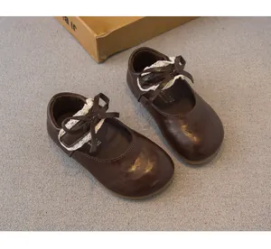 Detailansicht brauner Leder-Kinderschuhe für Mädchen mit eleganter Spitze und Schleife