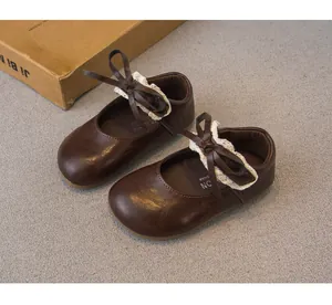 Detailansicht der dunkelbraunen Mary Jane Schuhe für Mädchen mit Schleife und Spitze