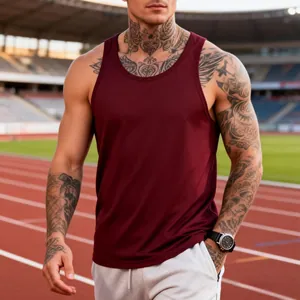 Man in burgundy quick-dry gym tank top posing on an athletic track stadium background