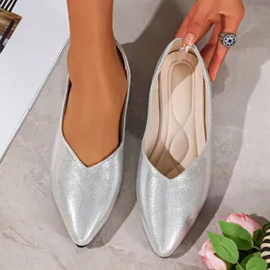 Close-up of silver pointed-toe flats with metallic finish and V-cut design