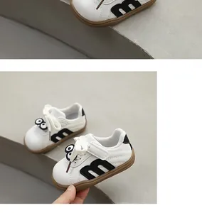 Close-up of toddler walking sneakers with cartoon eyes and soft brown sole.