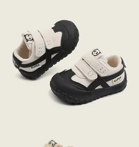 Close-up of black and white toddler walking shoes with cute panda logo and velcro straps