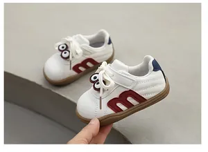 Detailed view of white toddler sneakers with cute cartoon eyes and soft soles