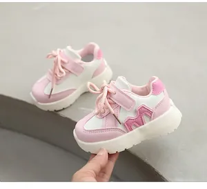 Détail de baskets pour enfants roses et blanches avec scratch et logo M sur le côté