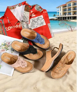 Sandales compensées à fleurs pour femmes en plusieurs couleurs sur une plage ensoleillée