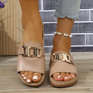 Detailansicht beigefarbener Keilsandaletten mit goldener Metallschnalle und Peeptoe-Design
